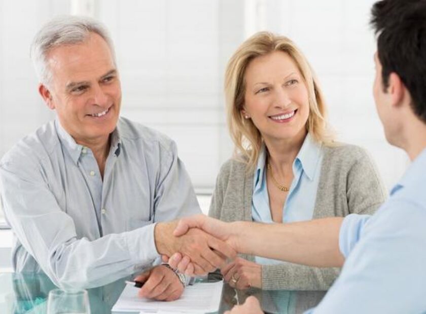 19339638 - senior happy couple shaking hand with financial advisor